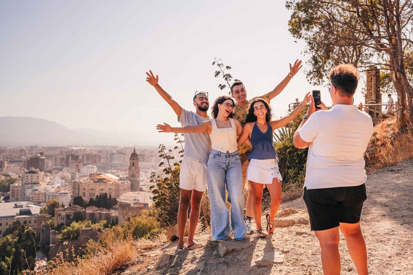 A group of people standing on a hill with a cityscape in the background. 3