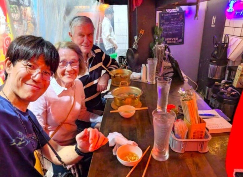 A group of people sitting at a table with a variety of dishes and utensils. 2
