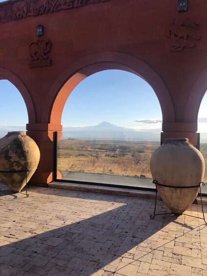 A view through arches overlooking a landscape with a mountain. 5