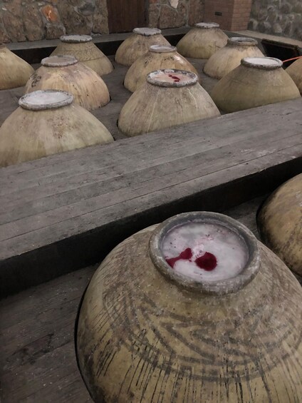 Large clay pots arranged on wooden platforms. 4