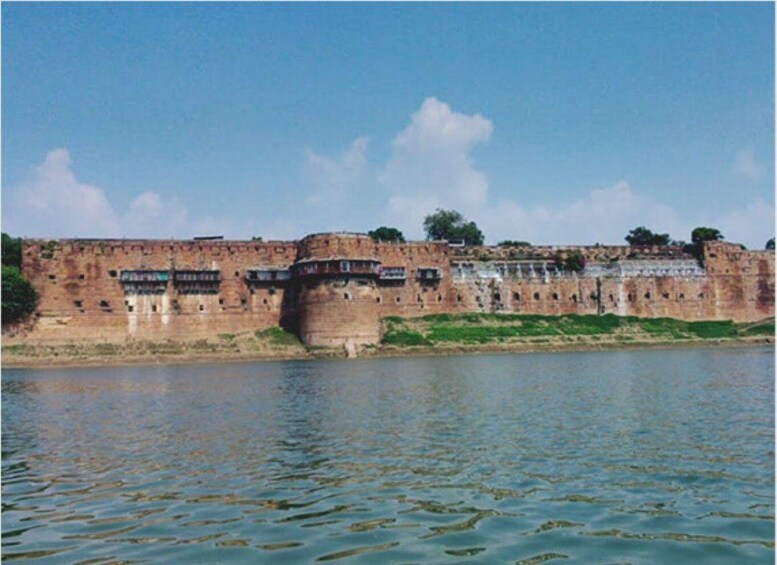 A large, ancient stone fortification by a river. 4
