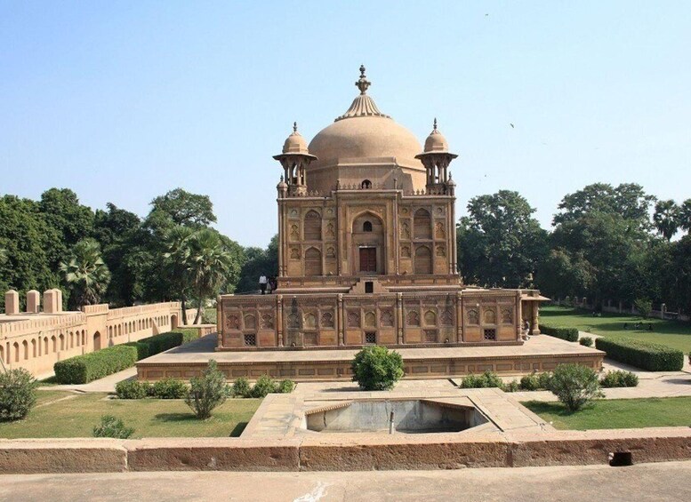 A large, ornate building with domes and intricate carvings, surrounded by a well-maintained garden and a clear sky. 5