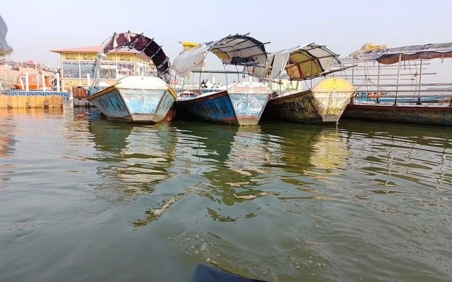 Several boats docked at a harbor with their covers open. 2