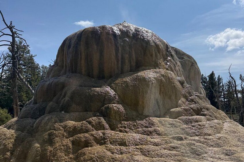 A large rock formation with a rounded top and a flat base, surrounded by sparse vegetation. 5