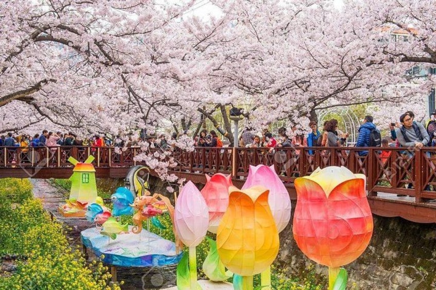A park with cherry blossoms, a bridge, and colorful paper lanterns. 4