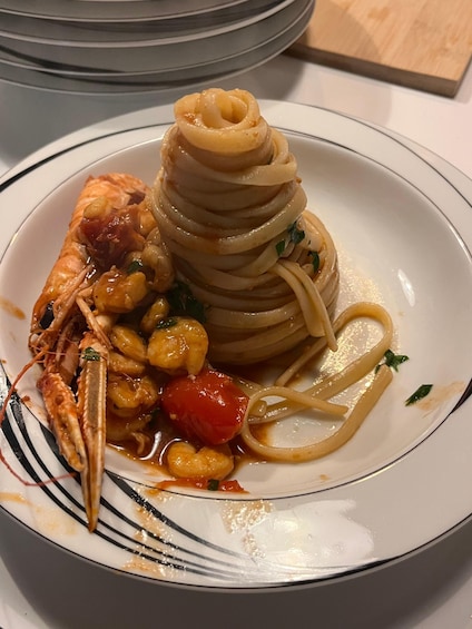 A plate of pasta with shrimp, clams, and cherry tomatoes. 5
