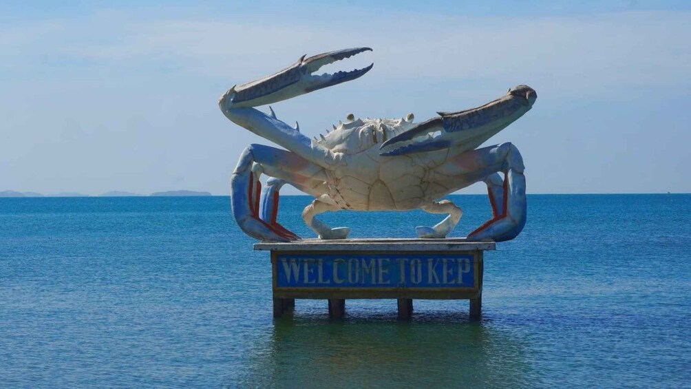 A large crab statue on a platform with a sign that reads "WELCOME TOKEP". 5