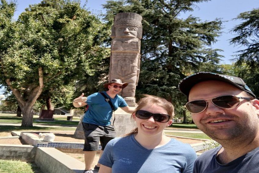 Un monumento con una estatua, una persona con una camisa azul y otra con gorra. 2