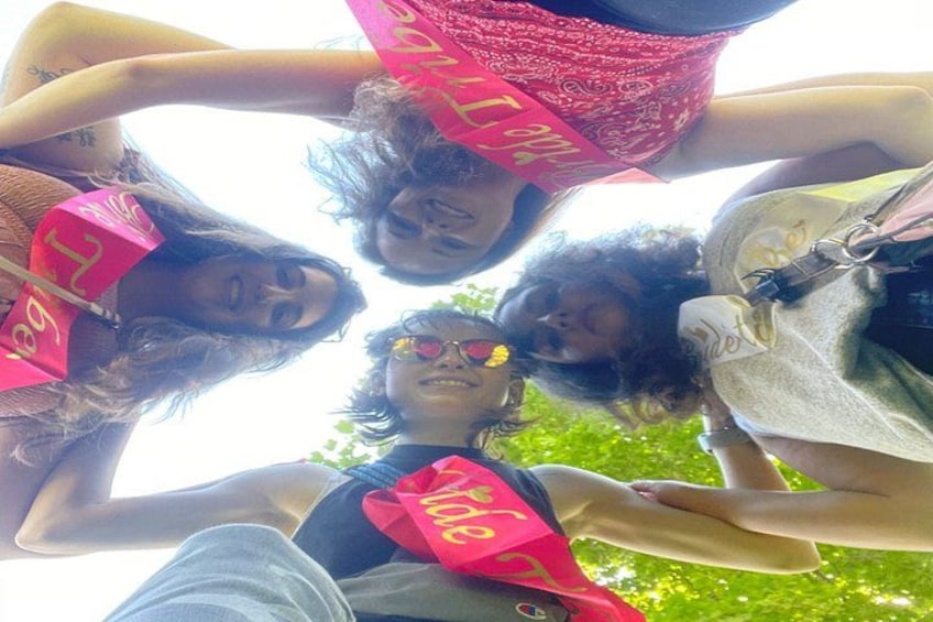A group of people in a circle, holding pink signs with text. 2