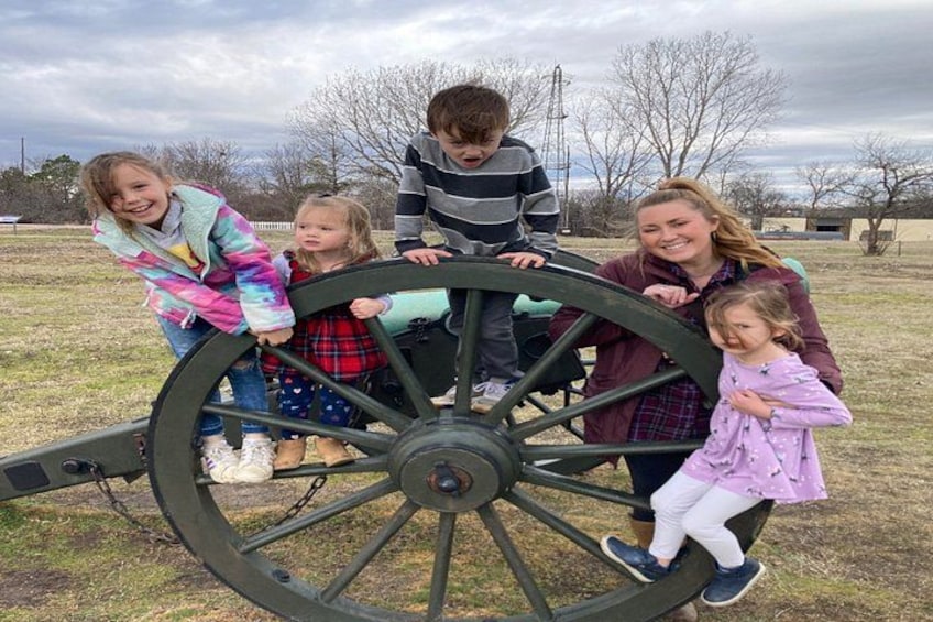 A group of people around a large, stationary wagon wheel. 2