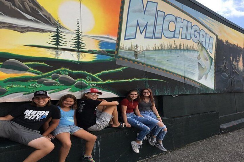 A mural of Michigan's landscape with a sunset, a lake, and mountains. 5