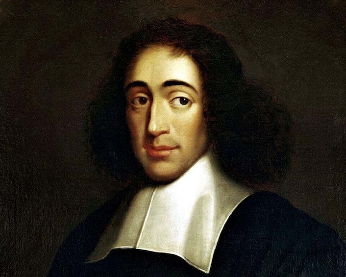 A portrait of a person with curly hair, wearing a dark coat with a white collar. 1