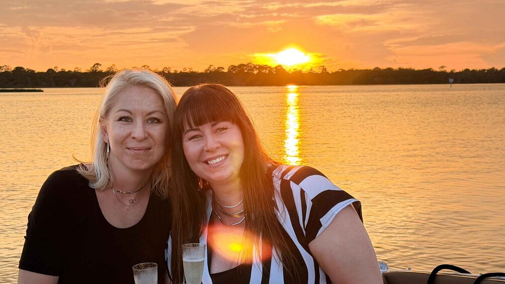 Two people sitting by a lake at sunset. 2