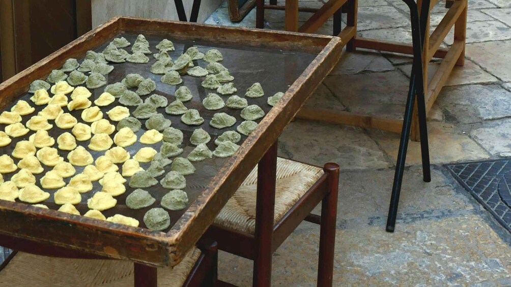 A tray with green and yellow doughnuts on a wooden table. 4