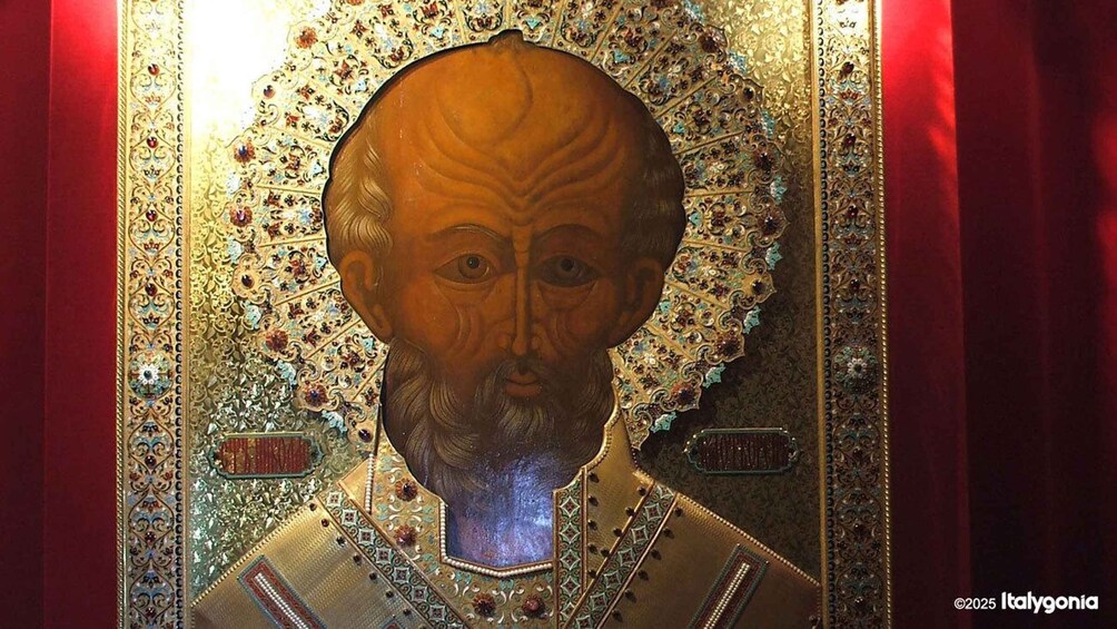 A religious icon with intricate gold and jewel detailing, set against a red background. 2