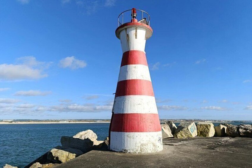 A red and white striped lighthouse by the sea. 3