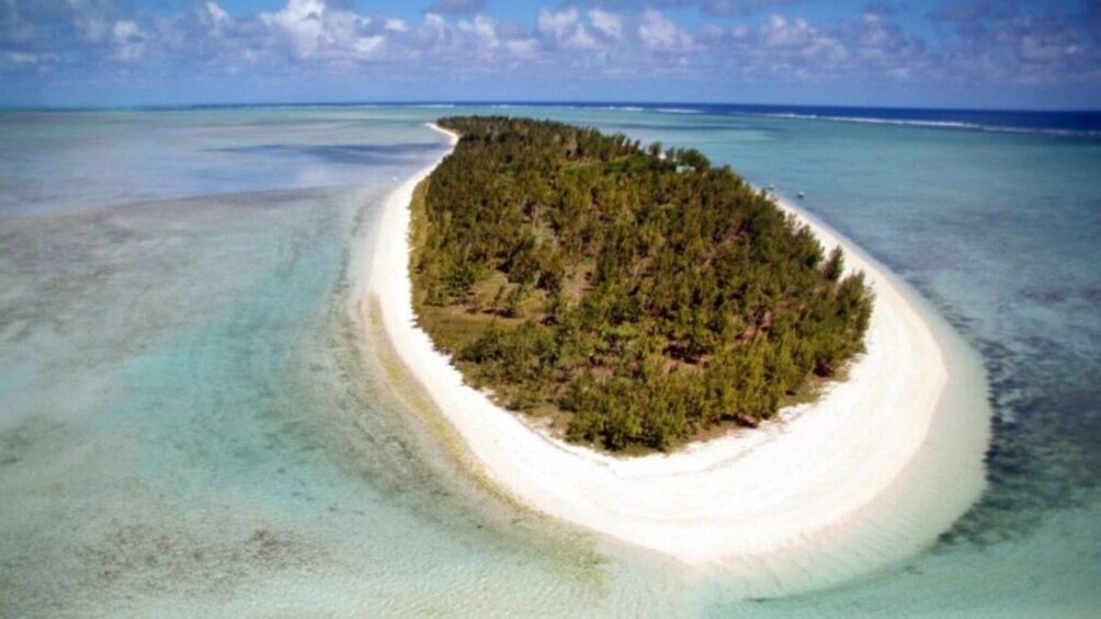 An aerial view of a crescent-shaped island with a white sandy beach and dense green forest. 3