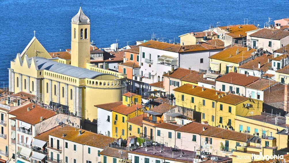 A coastal town with a prominent church featuring a bell tower, colorful buildings, and a clear view of the sea. 3