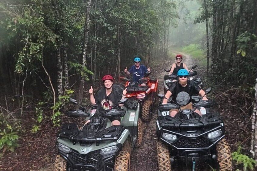Four people on all-terrain vehicles in a forested area. 3