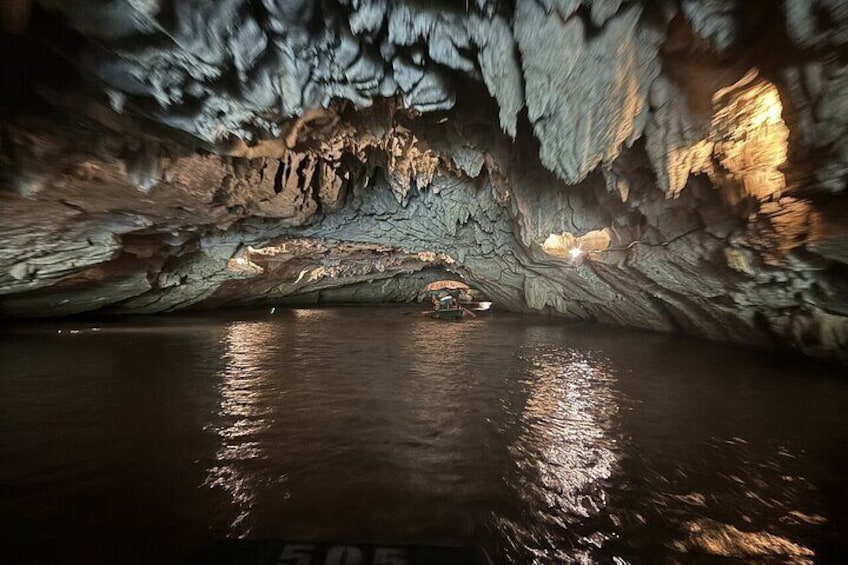 Una grotta con stalattiti e una barca nell'acqua. 5