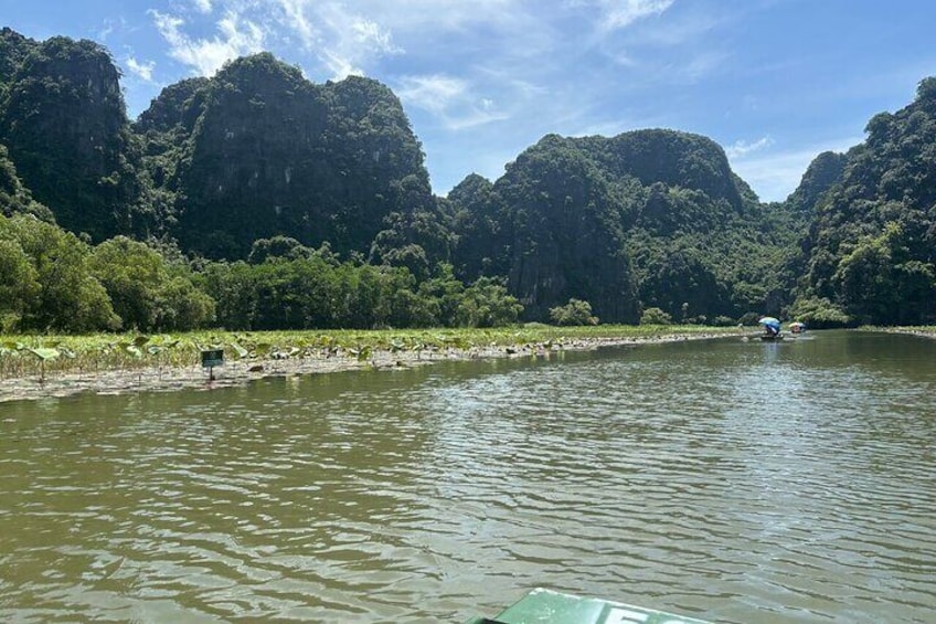 Un fiume con barche, circondato da colline verdeggianti. 4