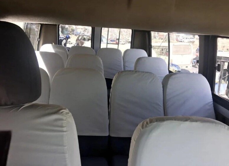 The interior of a bus with white seats and windows. 5