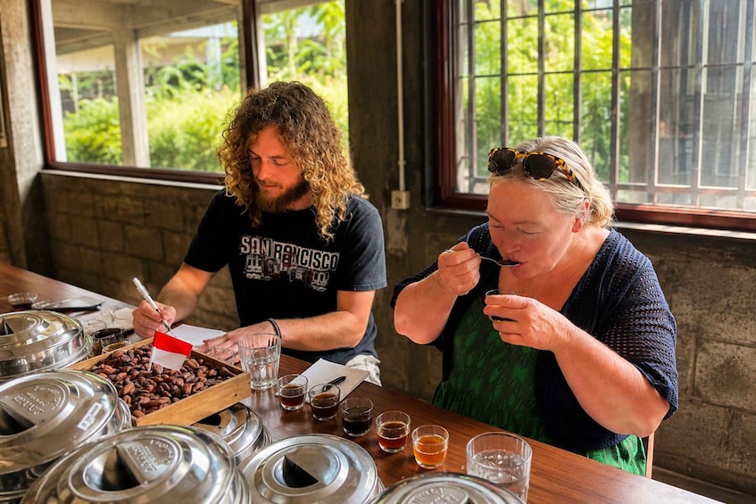 Two people at a coffee tasting event, surrounded by coffee beans and glasses of coffee. 4