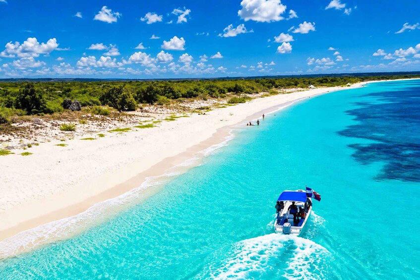 A boat on a turquoise beach with clear skies and a distant shoreline. 3