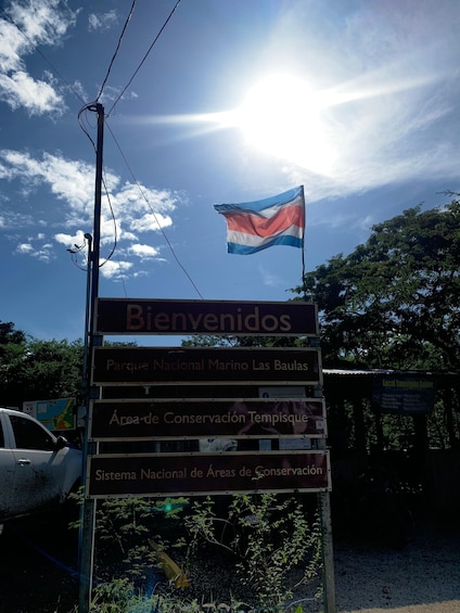 A sign with 'Bienvenidos' and 'Parque Nacional Marino Las Baulas' written on it. 5