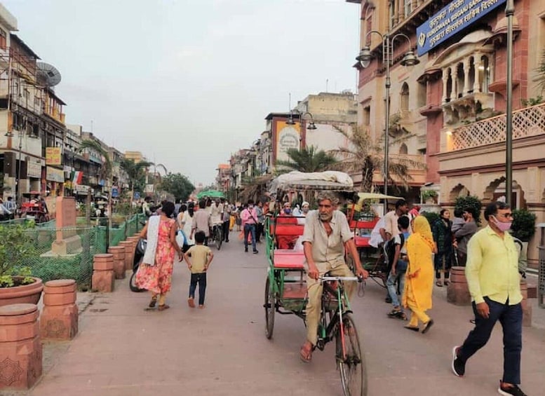 A busy street with pedestrians, a man on a bicycle, and a rickshaw. 2