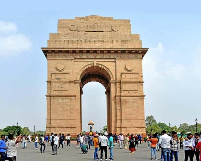 The India Gate with a crowd of people in front. 5