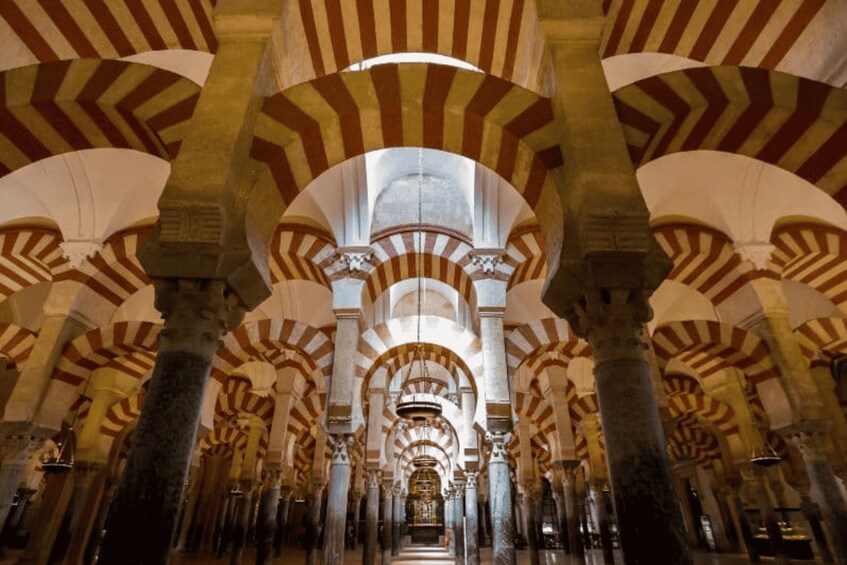 A mosque interior with arches and columns. 5