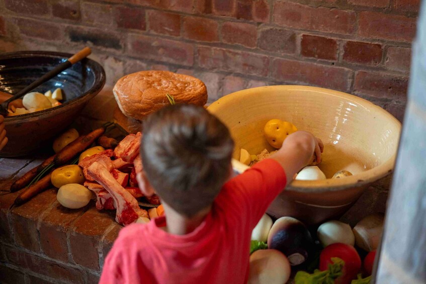 A child reaching into a large bowl filled with eggs. 3