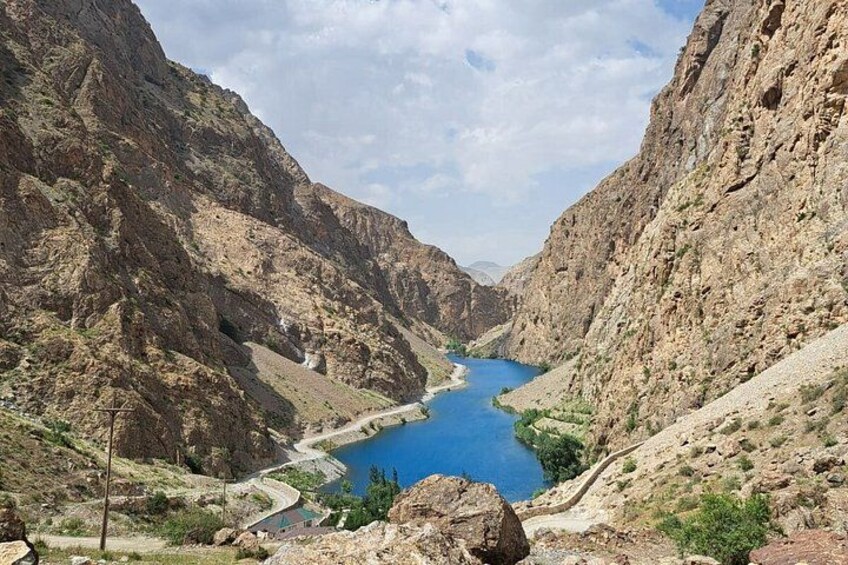 A canyon with a river, rocky terrain, and a clear sky. 5