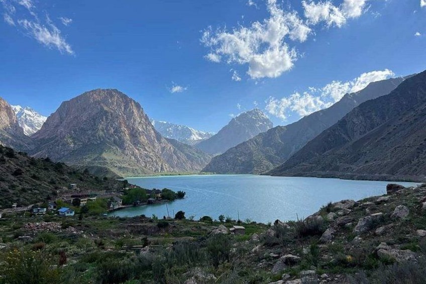 A mountain lake with a clear sky, surrounded by rugged mountains and sparse vegetation. 3