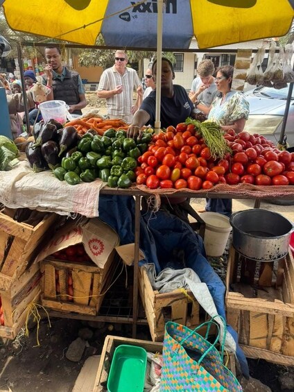 A market stall with fresh vegetables like tomatoes and peppers, surrounded by wooden crates and a yellow umbrella. 5
