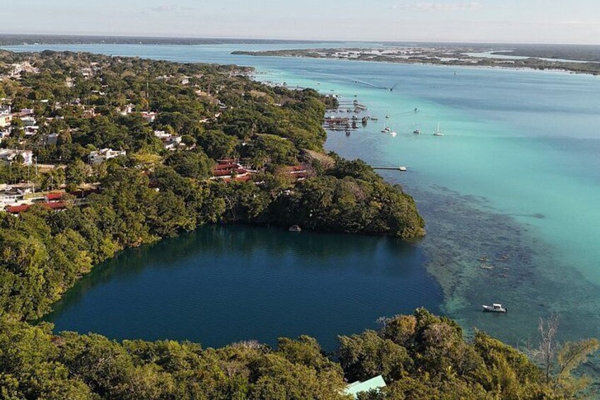 A coastal town with a large bay, boats, and a forested area. 5