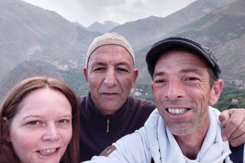 Trois personnes se trouvent dans un paysage montagneux, caractérisé par un terrain rocheux et une végétation clairsemée. 2