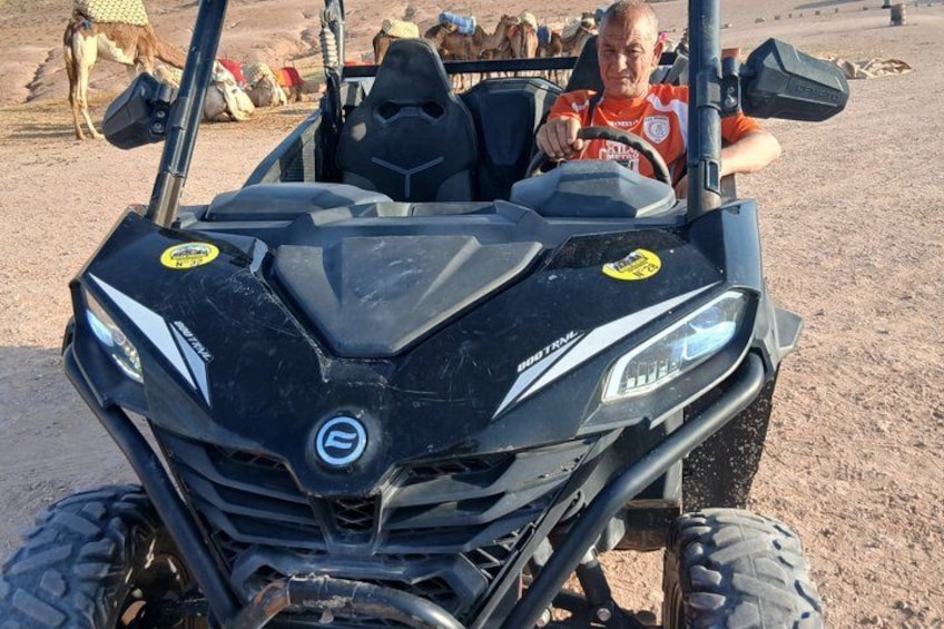 Un quad noir avec un logo sur le devant, un volant et un conducteur portant un t-shirt rouge. 3