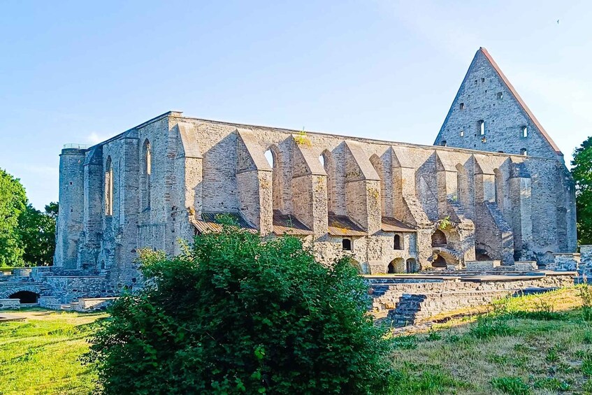A large stone building with a prominent triangular roof and multiple arched windows. 3