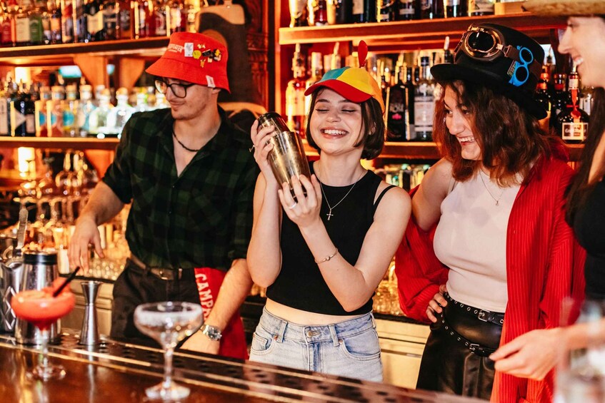 A bar with people, bottles, and a cocktail shaker. 2
