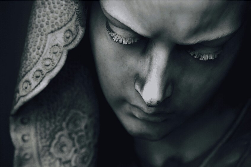 A close-up of a person's face with closed eyes and a patterned fabric. 2