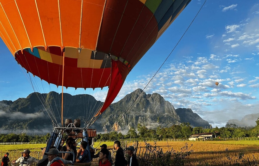 A hot air balloon with passengers and crew over a mountainous landscape. 1
