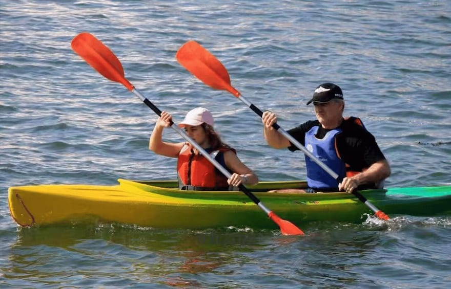 Two people kayaking on a calm body of water. 4