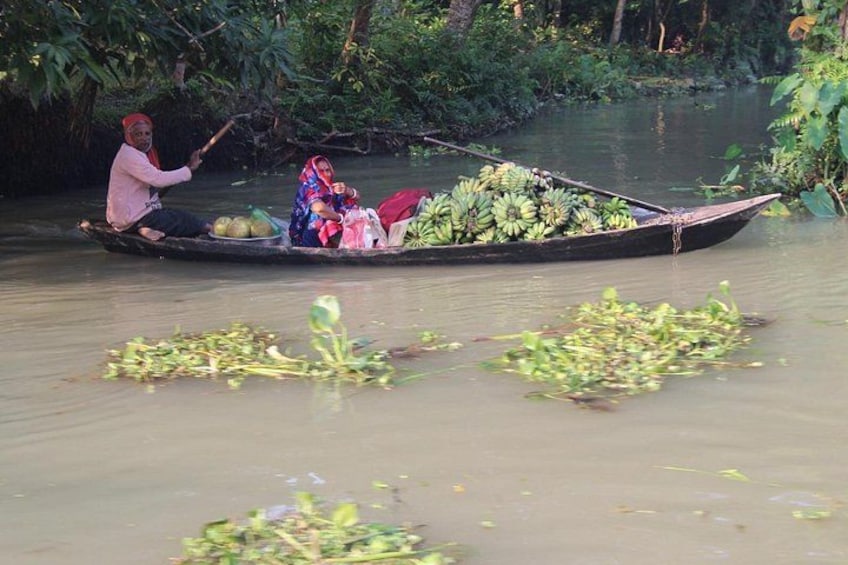 Ein Fluss mit einem Boot, das Bananen und eine Person transportiert, die rudert. 4