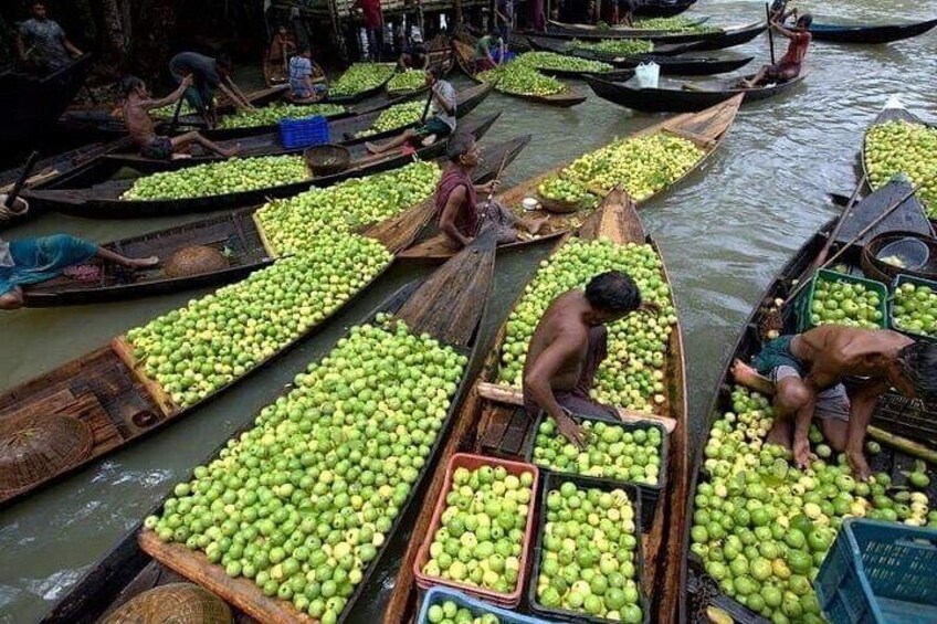 Canoe piene di frutta verde su un fiume. 1