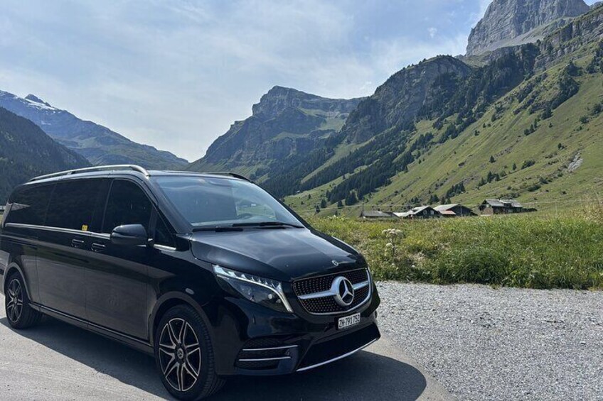 Una furgoneta negra Mercedes-Benz estacionada en una carretera con un paisaje montañoso al fondo. 3