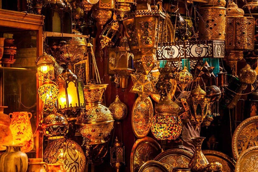 Ett stort urval av utsmyckade metallföremål, inklusive krukor, vaser och lyktor, utställda i en fullsatt butik. 4