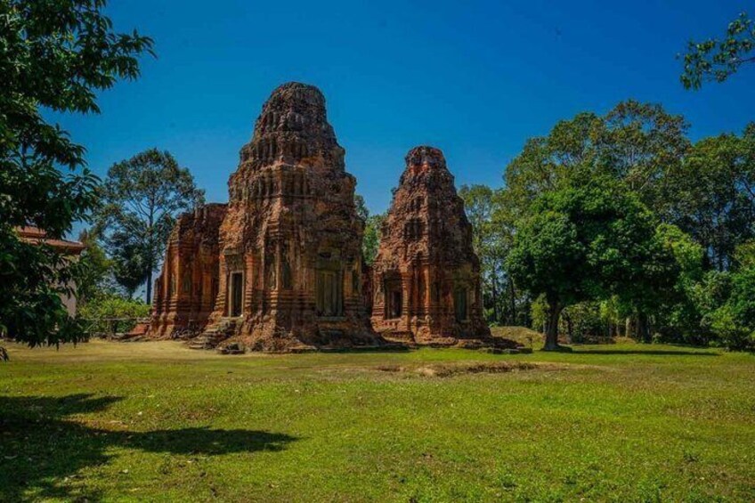 Ancient stone structures with intricate carvings, surrounded by lush greenery. 5