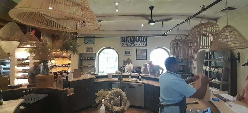 En barista som gör i ordning kaffe vid en bardisk på ett kafé, och ovanför disken hänger en skylt med texten: ”MILKMAID – fetthaltig mjölk”. 5